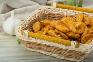 Croutons in a basket on wooden background photo