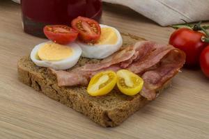 Bacon sandwich on wooden background photo