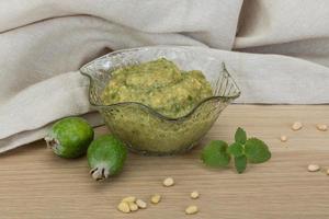 Feijoa jam in a bowl on wooden background photo