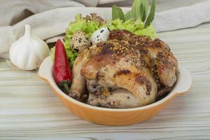 Quail grilled in a bowl on wooden background photo