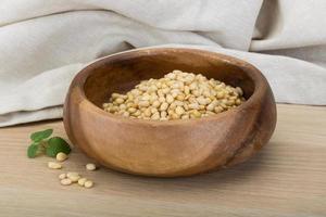 Cedar nut in a bowl on wooden background photo