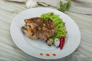 Quail grilled on the plate and wooden background photo