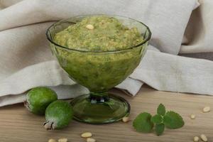 Feijoa jam in a bowl on wooden background photo