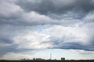 dark grey rain clouds over city in summer photo