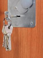 bunch of home keys in keyhole of door photo