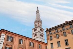 bell tower of Modena Cathedral under urban houses photo