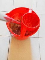 hisopo en balde rojo con agua espumosa foto