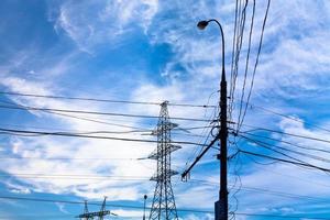 Electric power transmission under white cirrus clouds photo