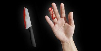 la mano de la niña sangraba por el dedo. y un cuchillo manchado de sangre que muestra lesiones accidentales en un fondo negro foto
