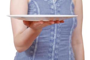 la mujer sostiene un plato blanco vacío en la mano foto