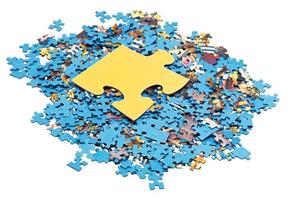 big puzzle piece on pile of disassembled puzzles photo