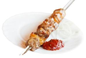 skewer of lamb shish kebab on white plate isolated photo