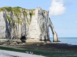 cliff with arch on beach of etretat photo