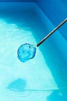 Cleaning of outdoor swimming pool by leaf net photo