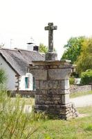 old stone cross in village de Breca, France photo