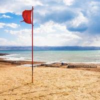 bandera roja en la playa en el mar muerto en temporada de invierno foto