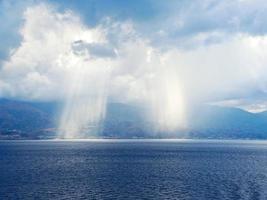 rayos de sol atravesando las nubes en el mar foto