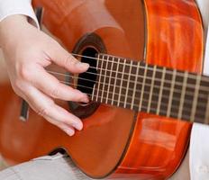 man plays on typical acoustic guitar photo