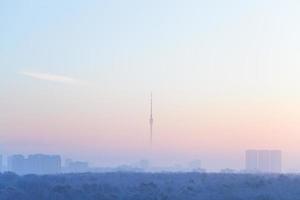 cielo rosa azul sobre la ciudad y la torre de televisión al amanecer foto