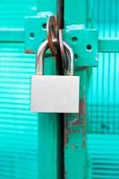 green door locked with steel padlock photo