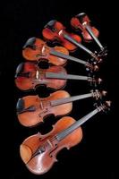 different sized violins on black photo