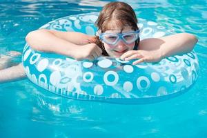 girl in swim goggle on inflatable circle photo