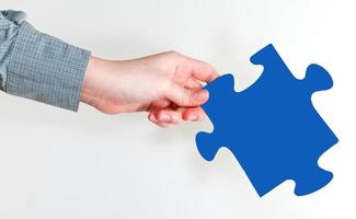 female hand holding blue puzzle piece photo