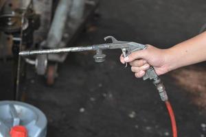 Dust removing Air Blow Gun in hand on blurred background. photo