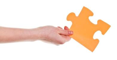 female hand holding big yellow paper puzzle piece photo