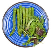 boiled green asparagus on plate isolated photo