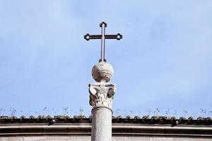 cruz medieval de metal en el cielo azul en roma foto