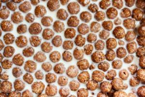 Chocolate corn balls on milk background texture, brown choco cereal balls pattern. healthy sweet snack for breakfast mockup with copy space top view photo