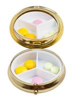 compact pill box with mirror and several tablets photo