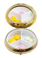 compact pill box with mirror and several tablets photo