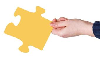 female hand with yellow puzzle piece photo