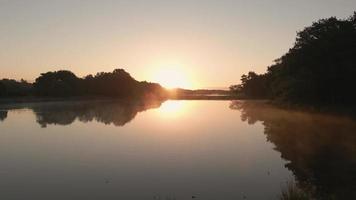Blick auf die Sonne, die sich in einer Flusslandschaft spiegelt video