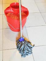 red bucket with foamy water and mopping the floor photo