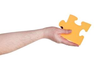 male hand holding big yellow paper puzzle piece photo