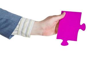 male hand holding big pink paper puzzle piece photo