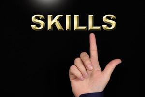 SKILLS text, a word written on a black background pointed to by a hand with the index finger of a person. photo