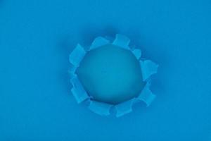 A blue sheet of paper with a hole in the middle. reminder. Background, texture. Copy space. photo