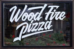 wood fired pizza, special text written on a glass display case photo