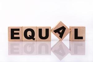 EQUAL word, text written on wooden cubes on a white background with reflection.