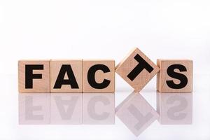 FACTS word, text written on wooden cubes on a white background with reflection. photo