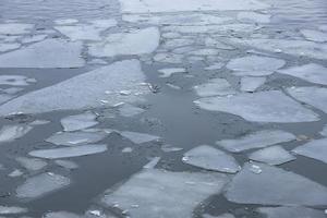 Spring thin ice on the surface of the river. Ice drift. photo