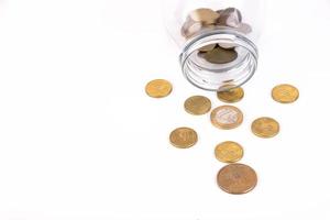 Metal coins pouring out of the can, on a white background. Copy space. photo