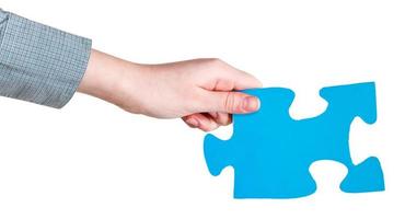 female hand holding big blue paper puzzle piece photo