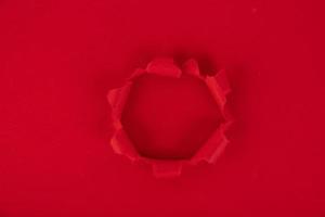 A red sheet of paper with a hole in the middle. reminder. Background, texture. Copy space. photo