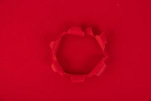 A red sheet of paper with a hole in the middle. reminder. Background, texture. Copy space. photo