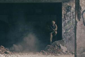 A bearded soldier in uniform of special forces in a dangerous military action in a dangerous enemy area. Selective focus photo